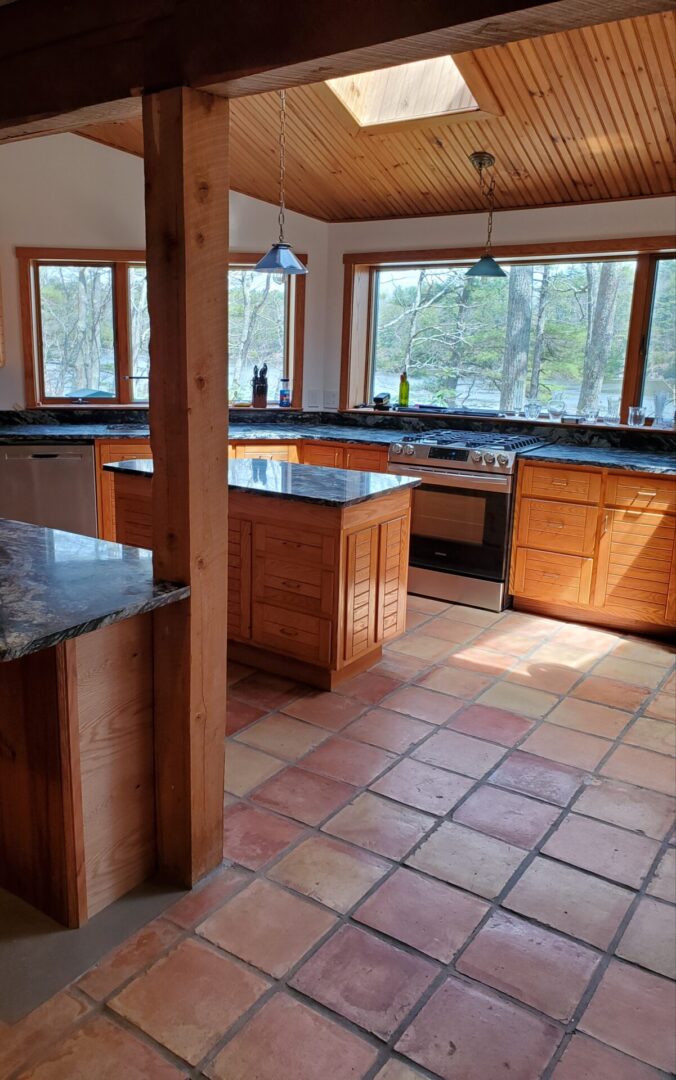 A kitchen with tile floors and wooden cabinets.