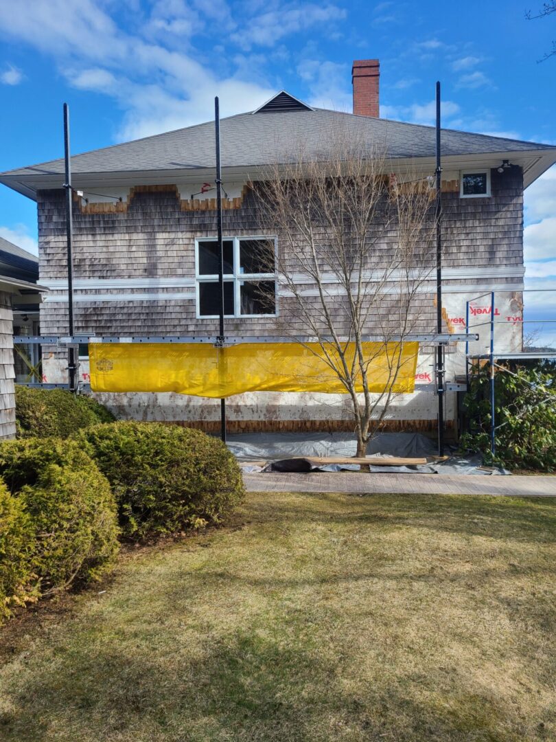 A house with a yellow roof and a fence around it.