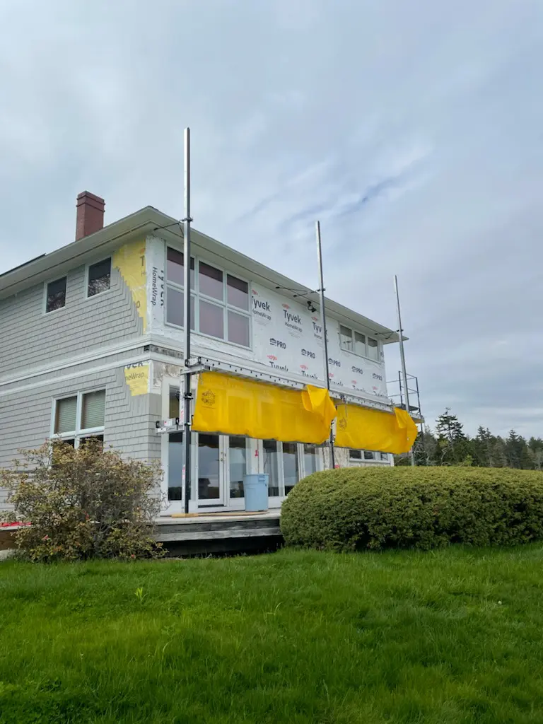 A house with yellow awnings on the side of it.