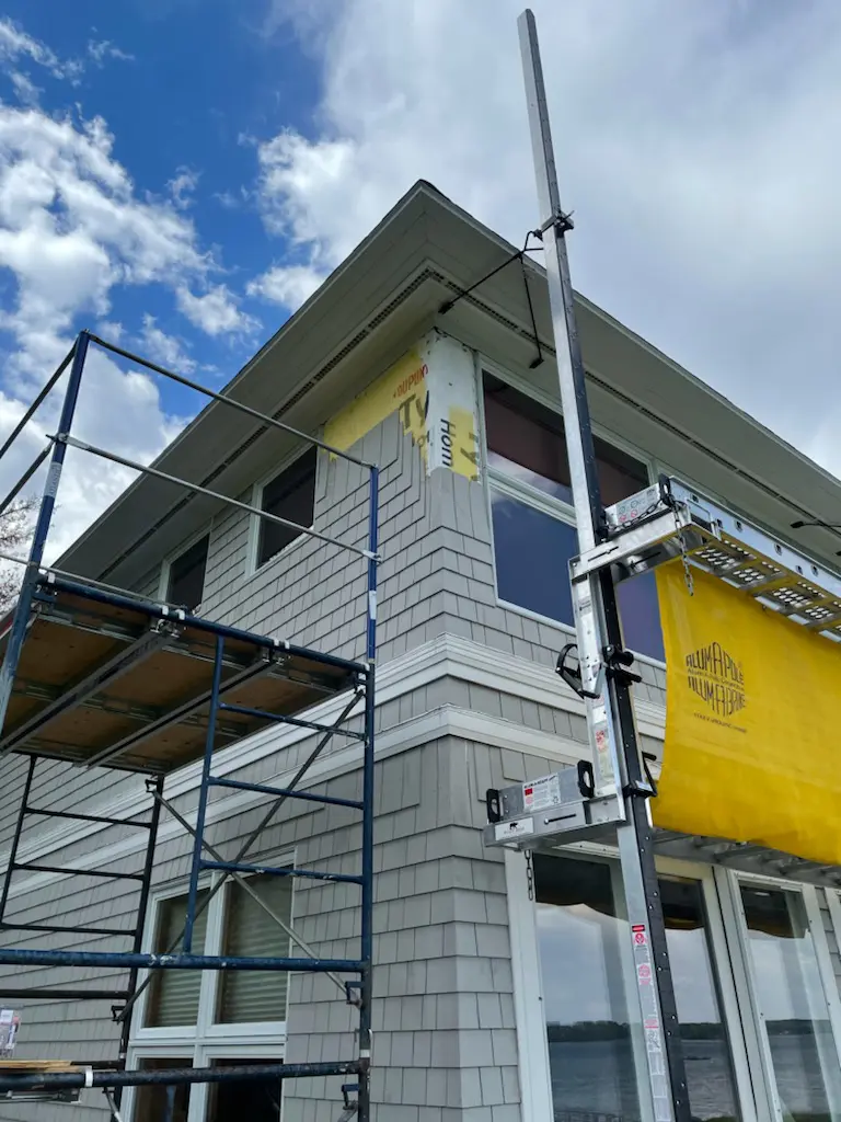 A building with scaffolding around it and a yellow sign on the side.