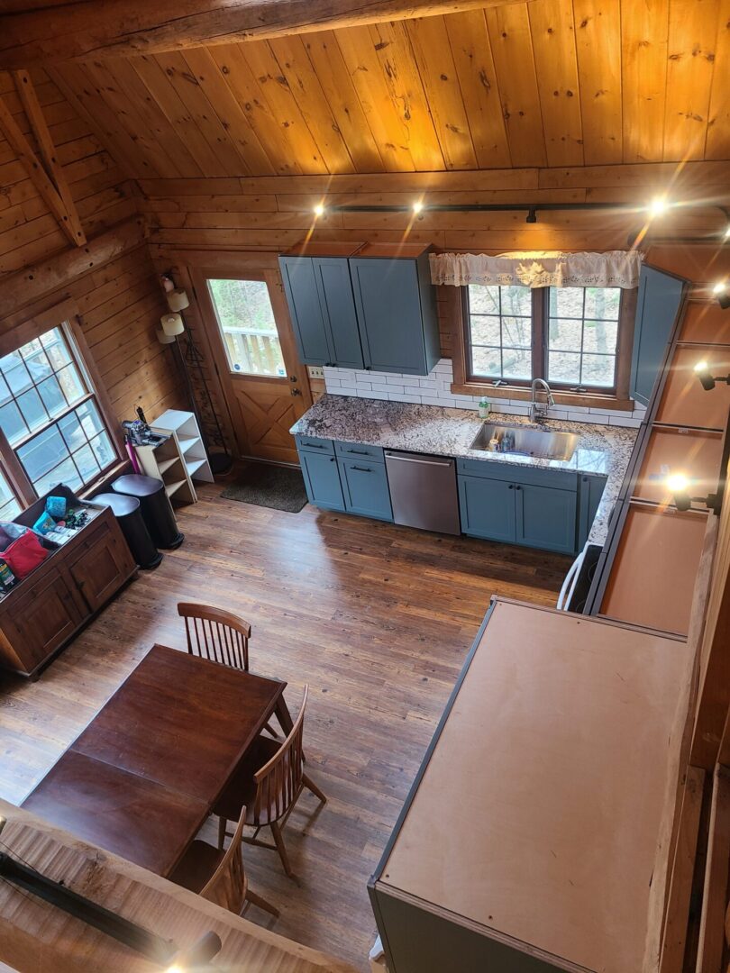 A kitchen with wood floors and blue cabinets.