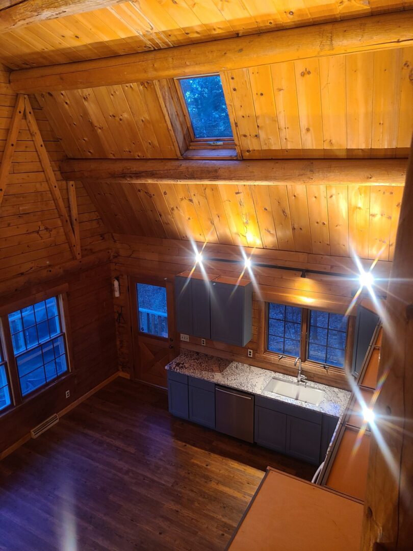 A kitchen with lights on and wood floors.