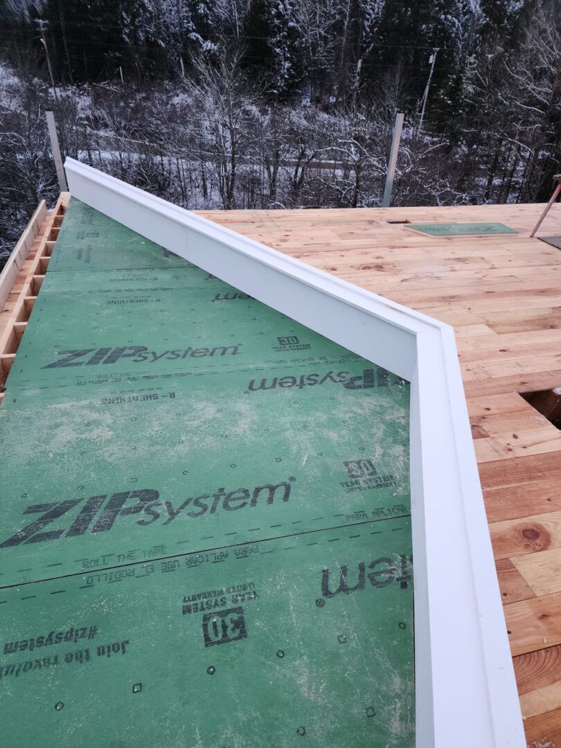 A green tarp covering the bottom of a roof.