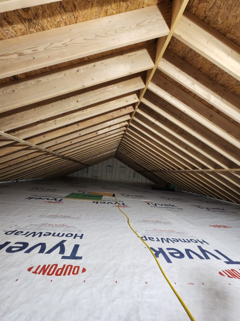 A view of the inside of an attic with insulation.