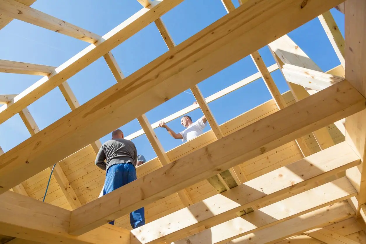 Two men standing on a wooden structure in the sky.