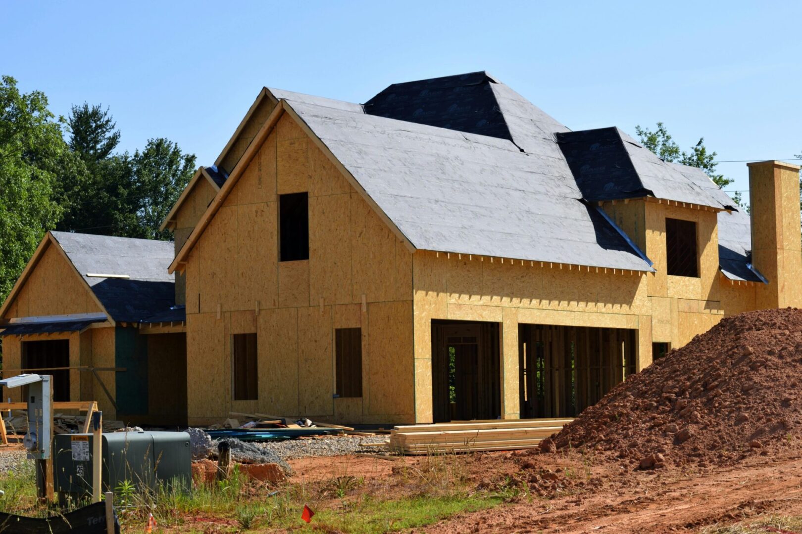 A yellow house with black roof and windows